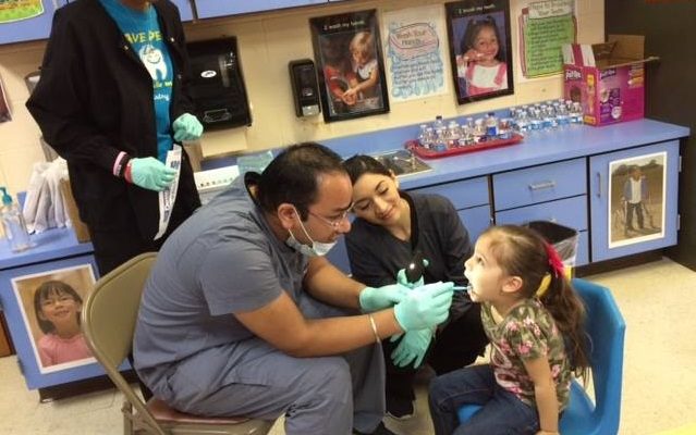 Photo: A Dentist examining a child's mouth.