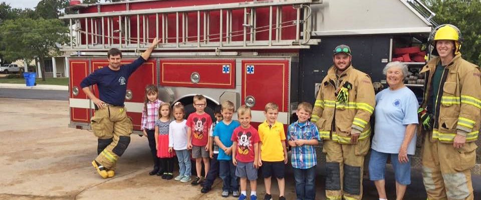 Photo: Firefighters and Head Start students pose with a fire engine